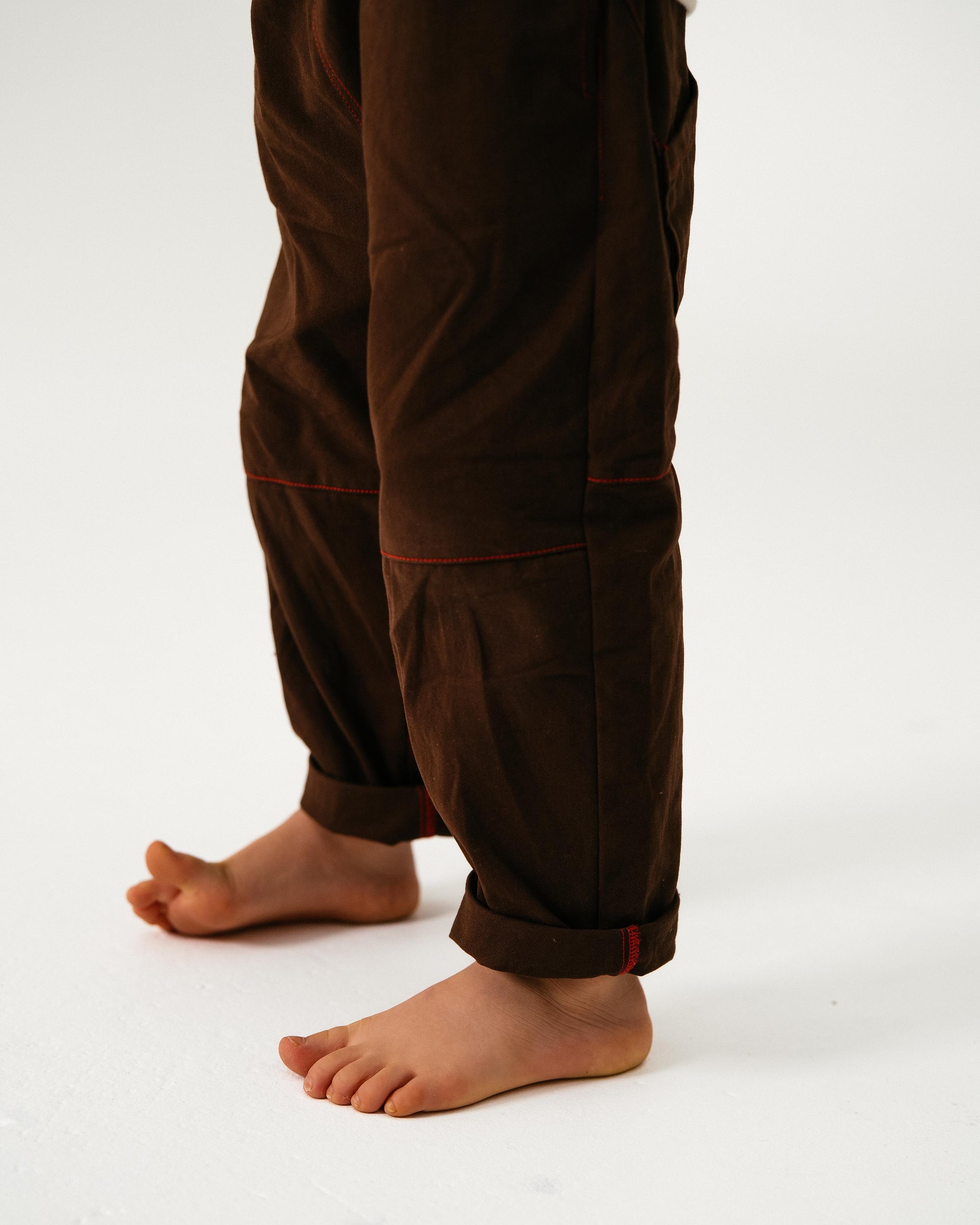 Brown pants worn by a child on a white background
