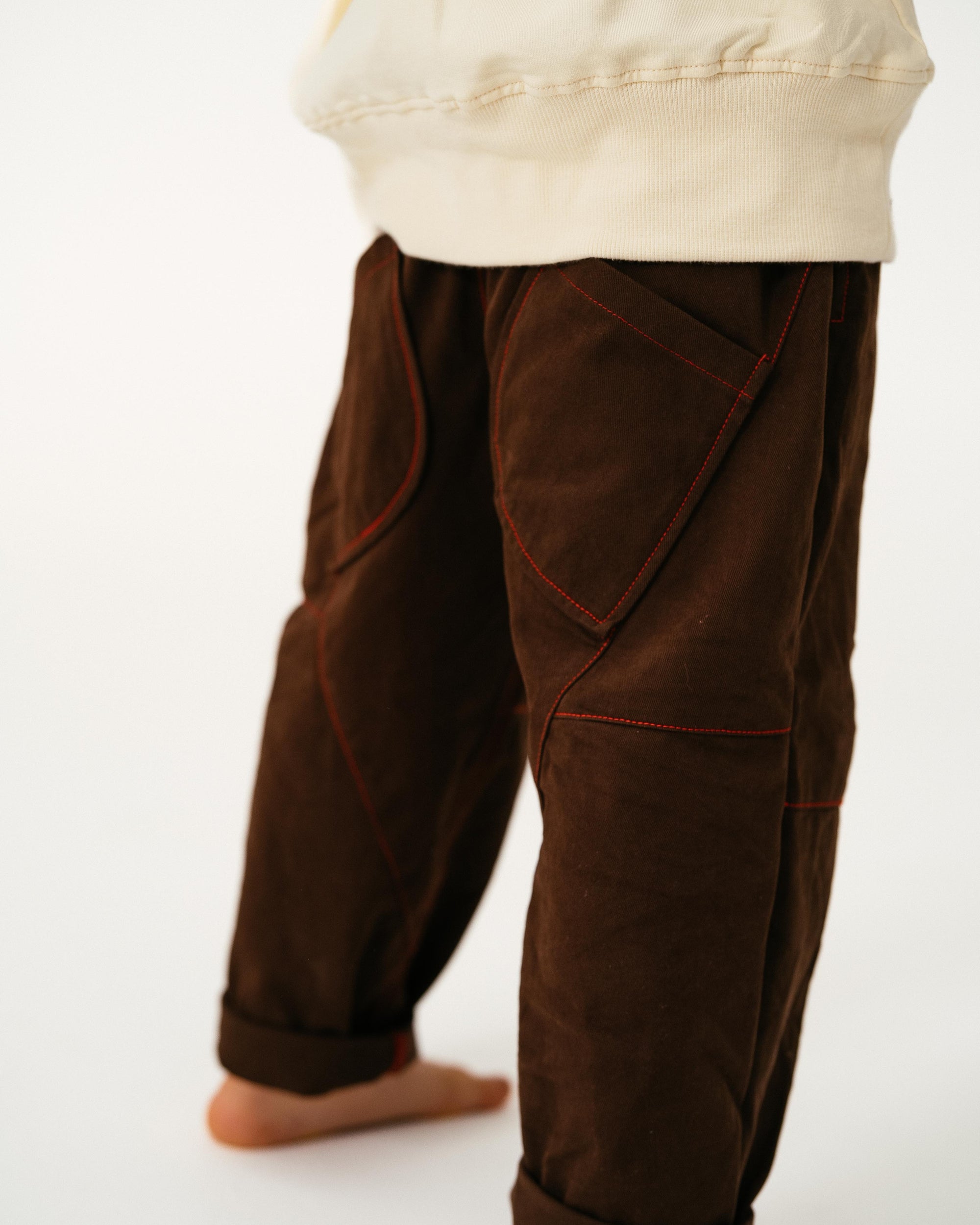 Brown pants worn by a person on a white background