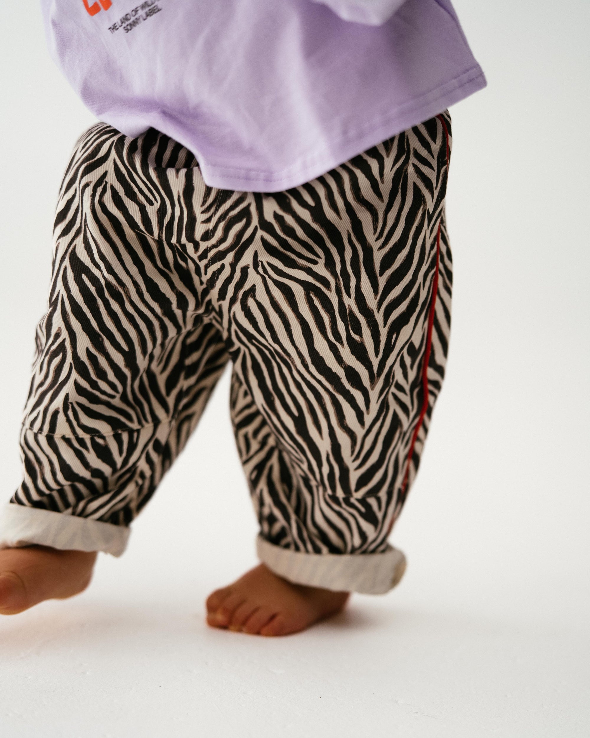 Zebra print pants worn by a child on a white background