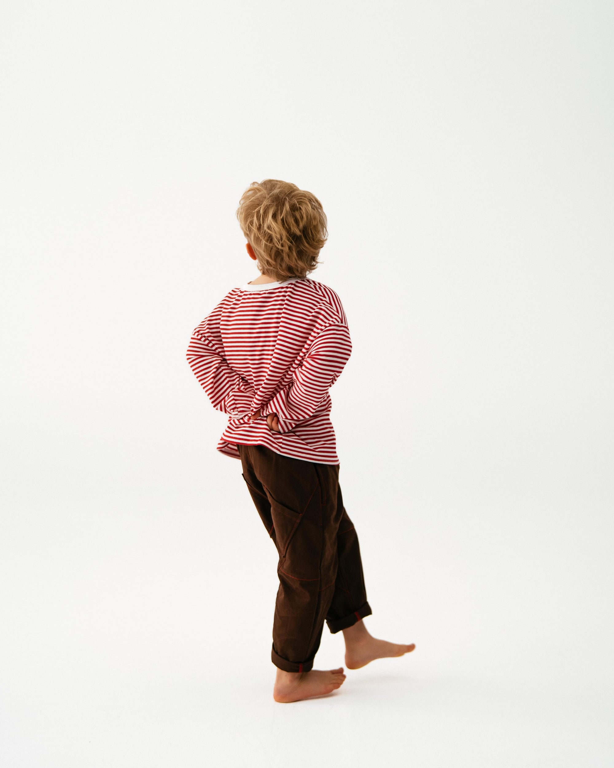 Person wearing a red and white striped shirt and brown pants on a white background