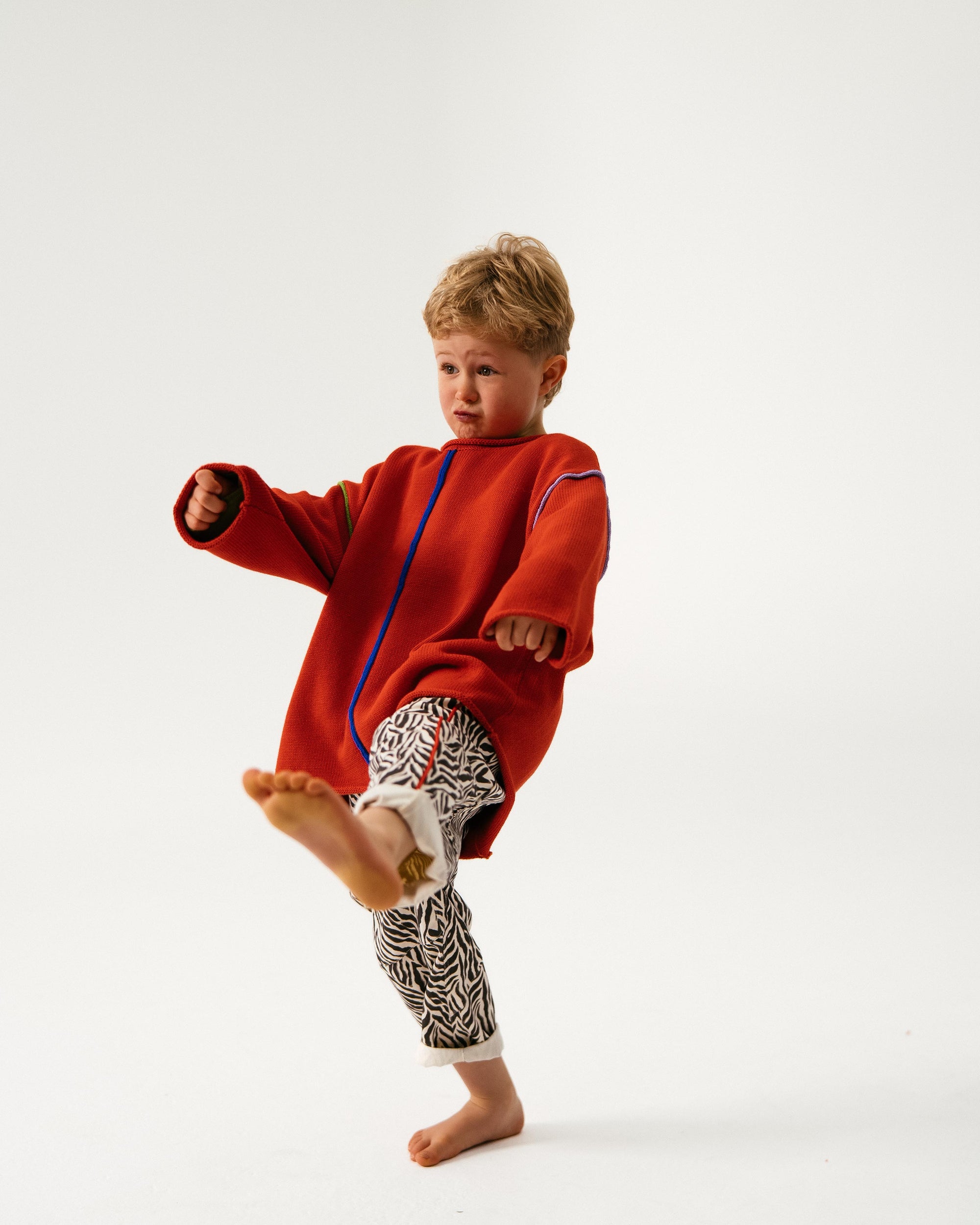 Child wearing a red outfit with a white background