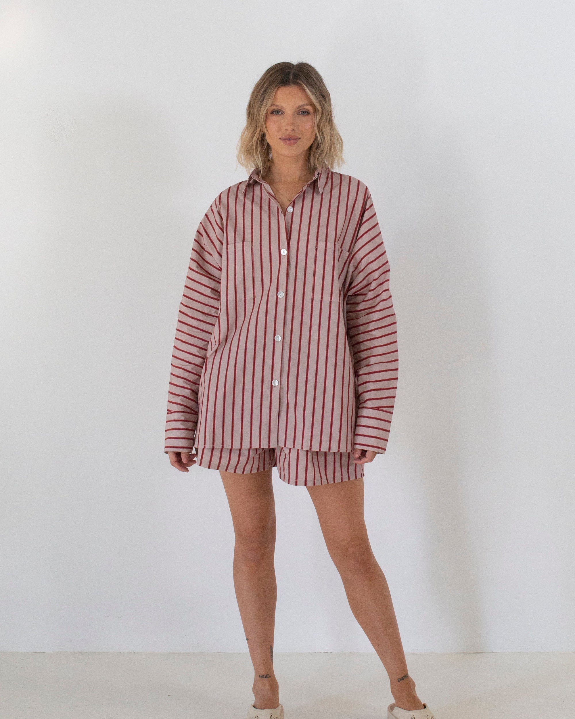 Woman wearing a striped shirt and shorts set on a white background